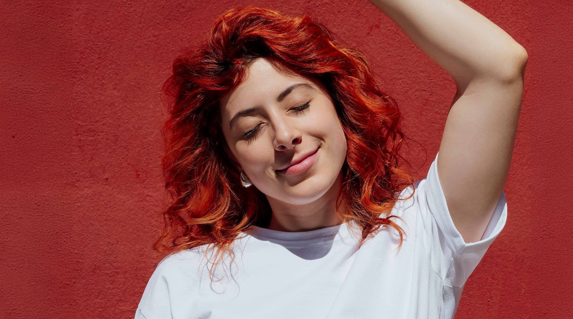 A woman enjoying her healthy, vibrant dyed red hair.